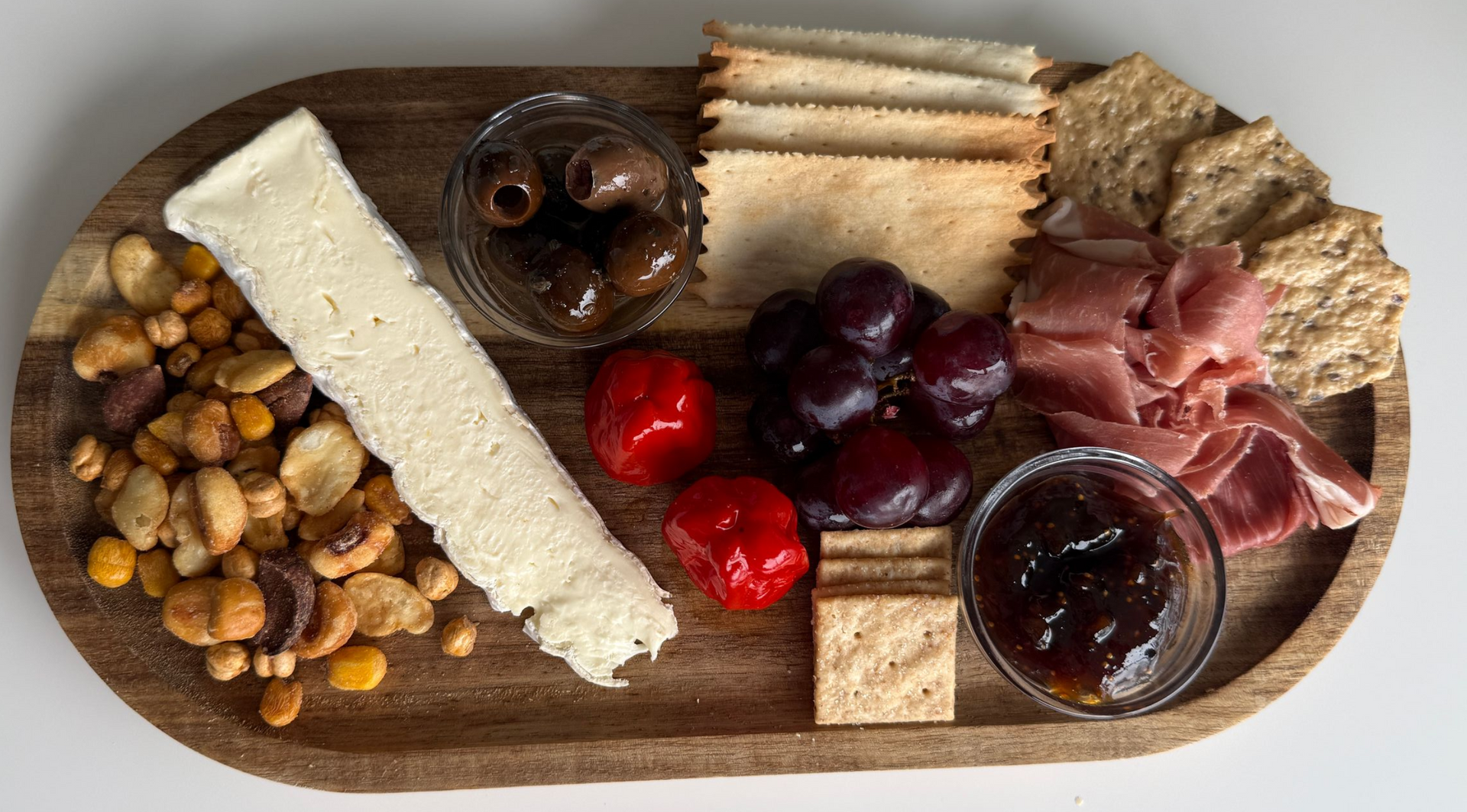Sandwich, chips, beer, soda, and wine on wooden table.