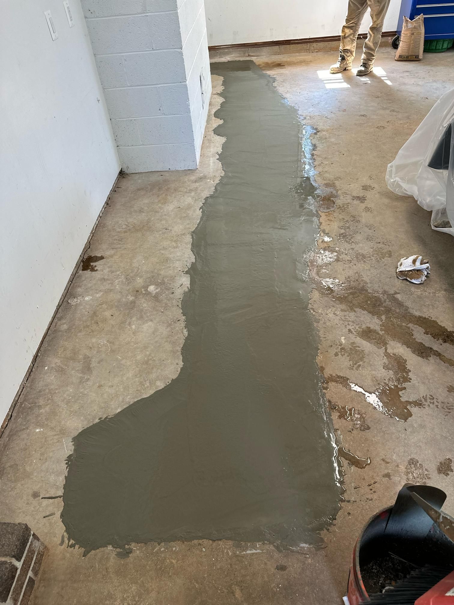 Freshly poured concrete strip on garage floor.