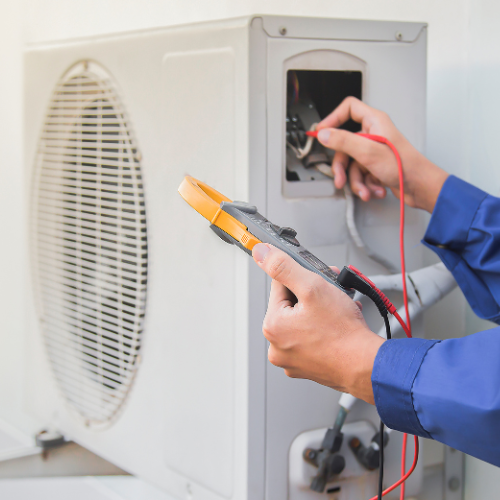 A person is working on an air conditioner with a multimeter