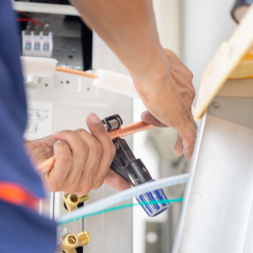 A man is working on a machine with a pair of pliers