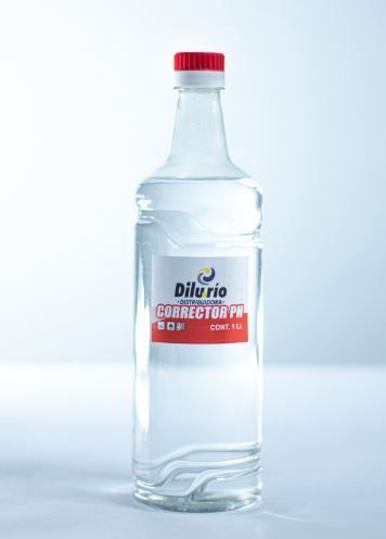 Botella de vidrio transparente con tapón rojo y etiqueta blanca, rotulada “Corrector pH”.