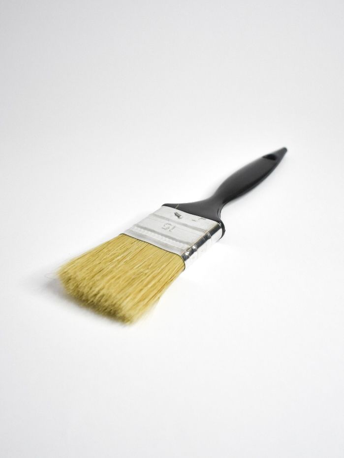 Pincel con mango negro sobre fondo blanco.