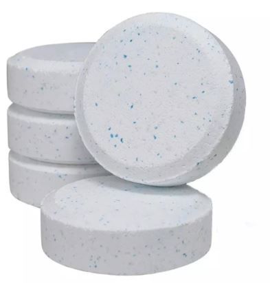 Pila de pastillas de cloro blancas y redondas con motas azules, utilizadas para la desinfectación del agua.