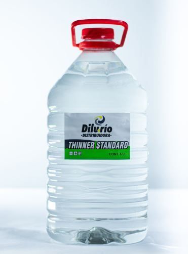 Botella de líquido “Thinner Standard”, con etiqueta blanca y tapón rojo.