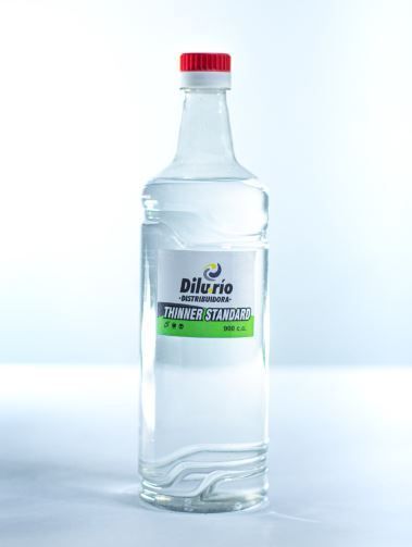 Botella de líquido “Dilurio” con tapón rojo y etiqueta blanca.