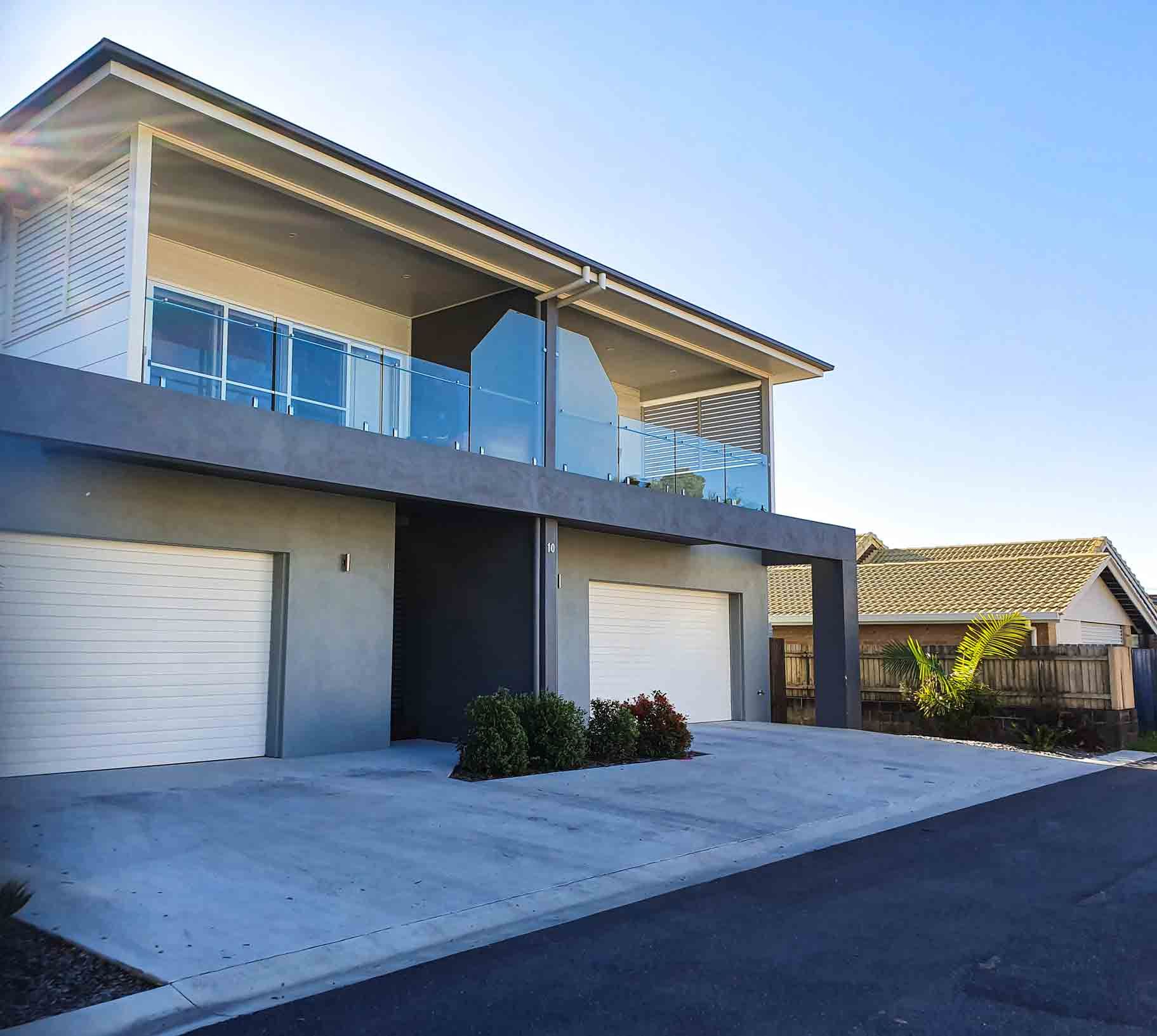 A large house with two garage doors and a balcony