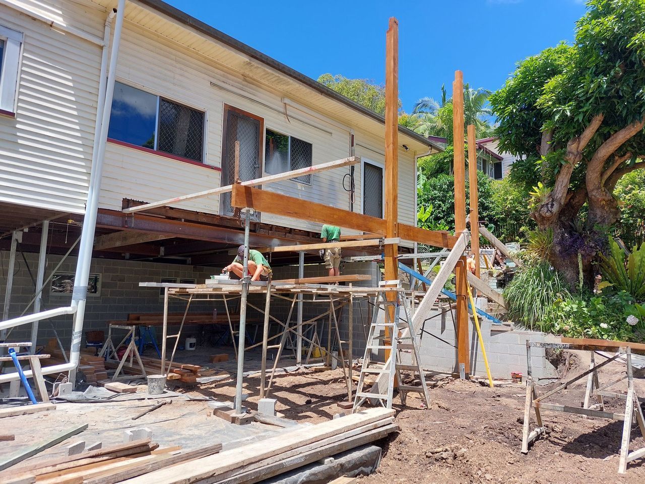 A house is being remodeled with a wooden deck being built.