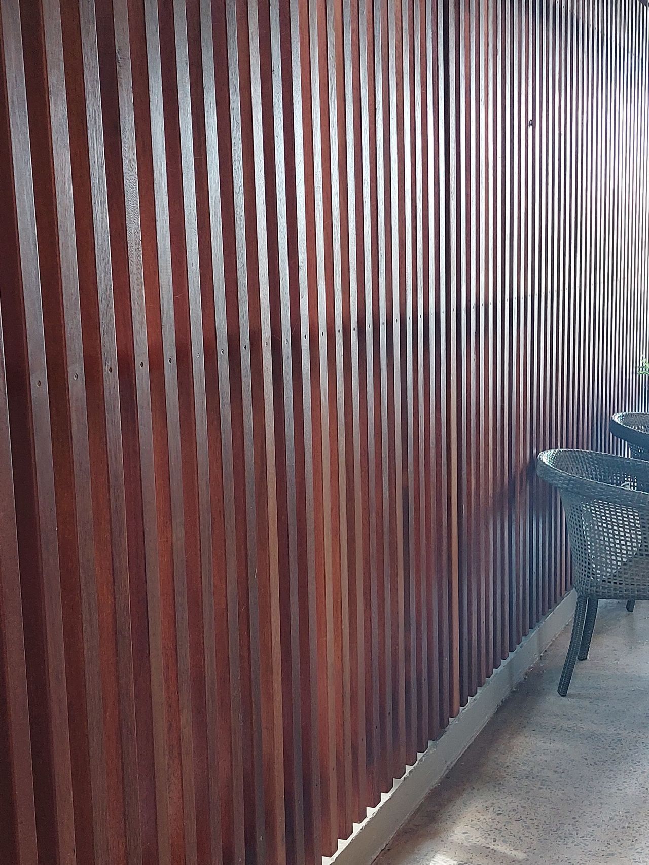 A wooden wall with a chair and a table in front of it.