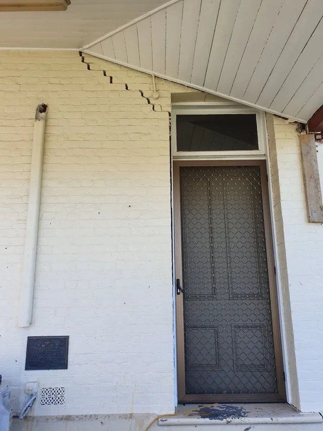 A white brick building with a black door