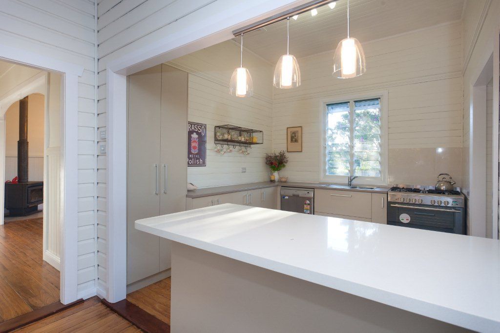 A kitchen with white cabinets and a white counter top