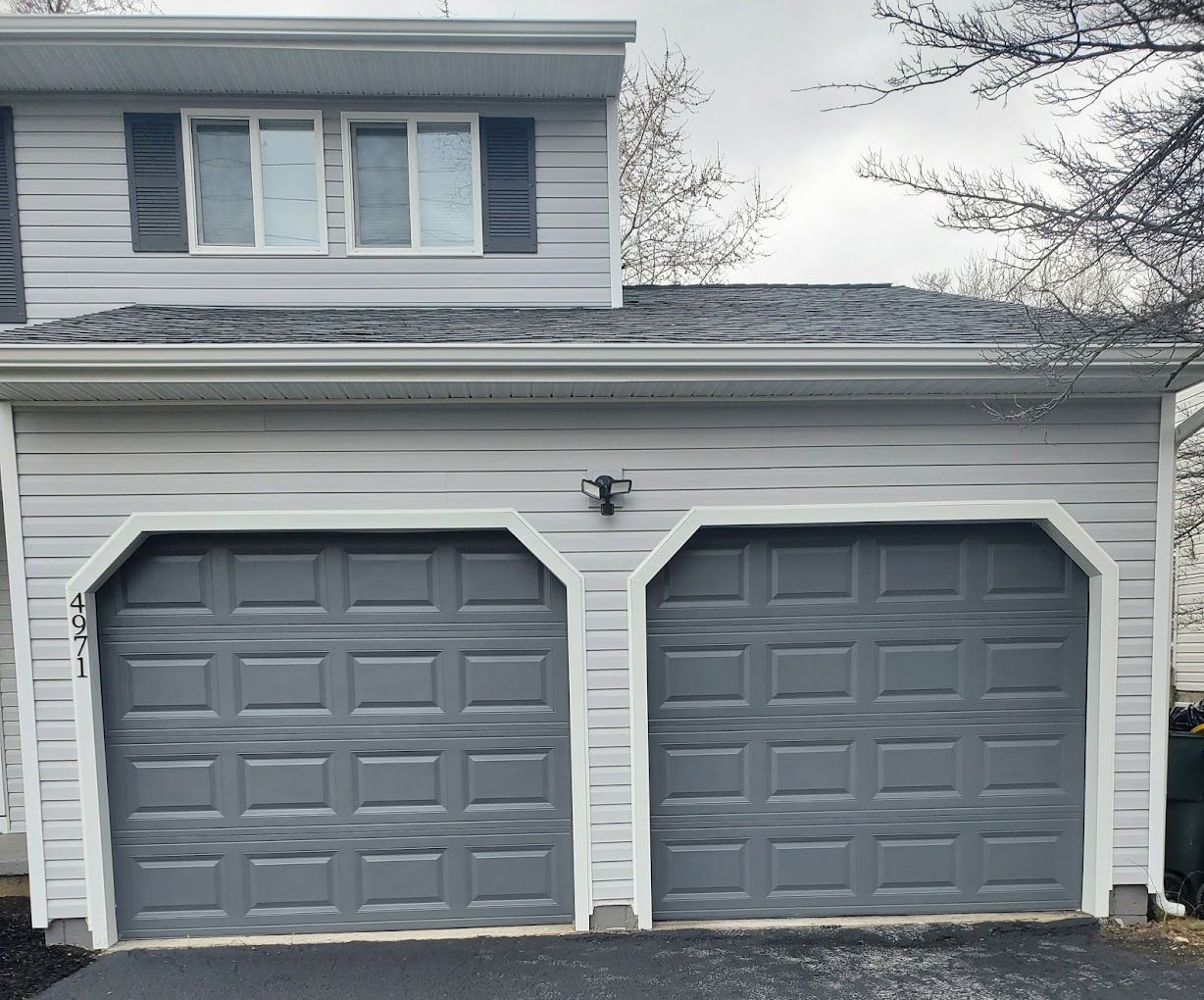 A house with two garage doors painted gray and white