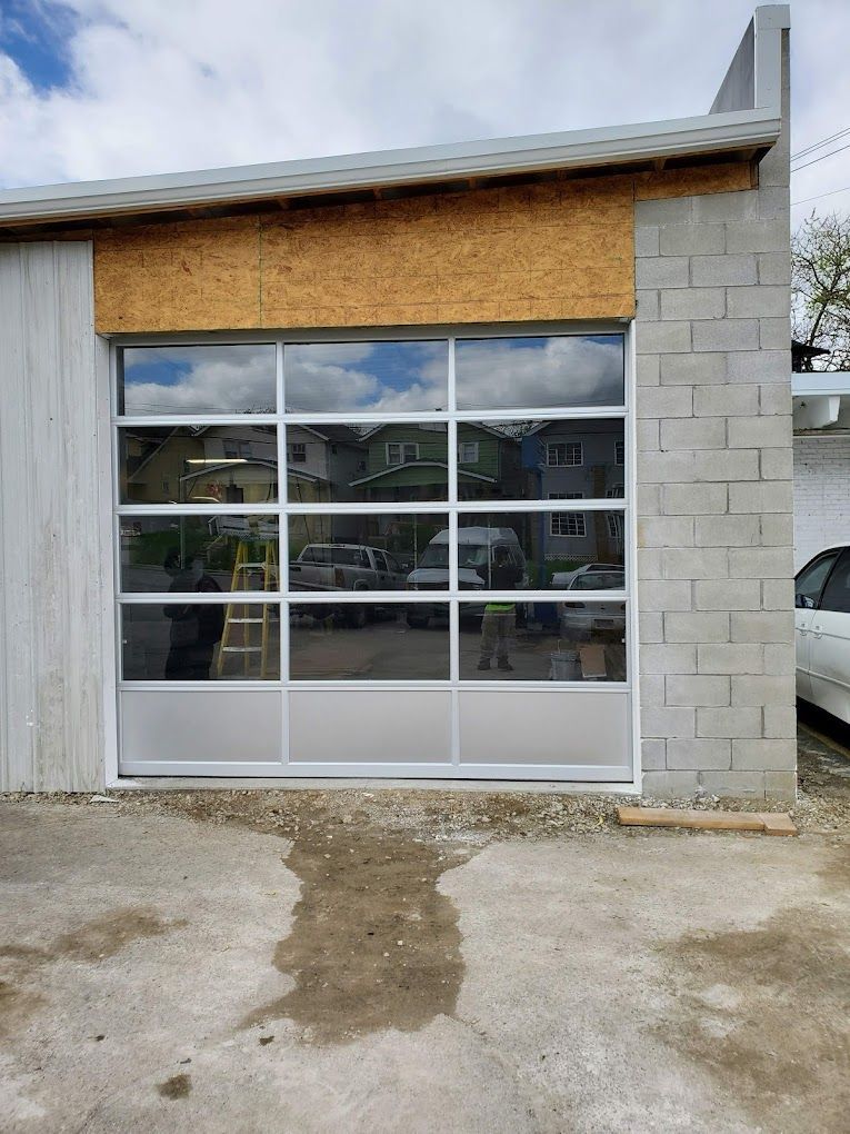 A garage door is being installed on a brick building.