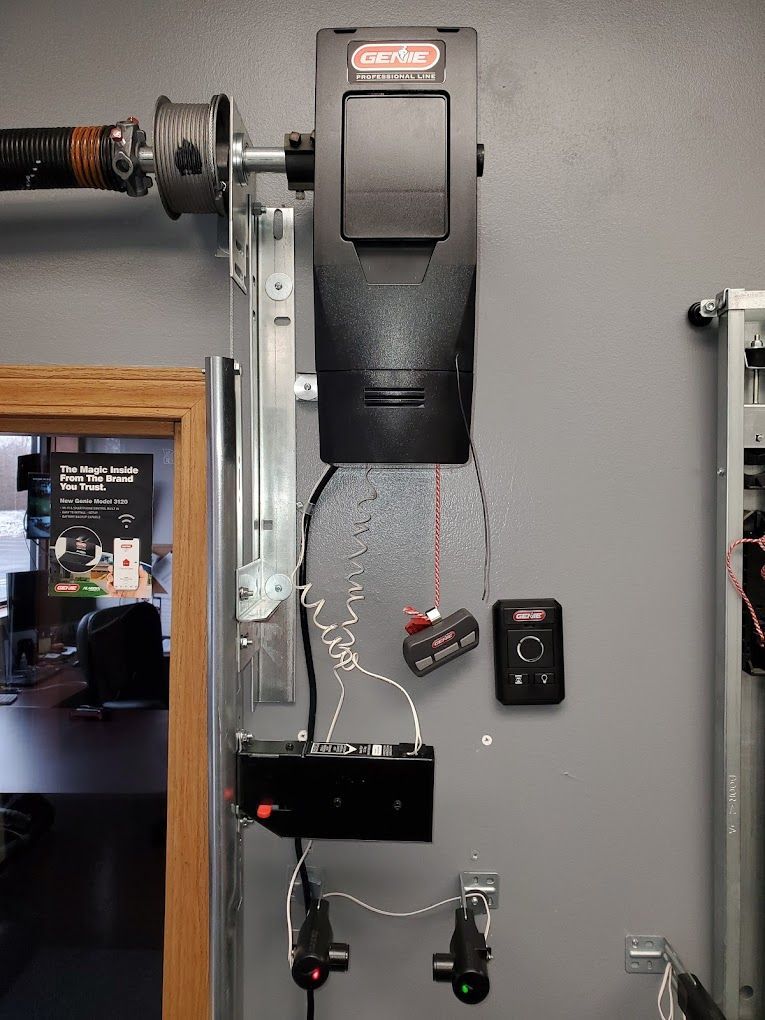 A garage door opener is hanging on a wall next to a door.