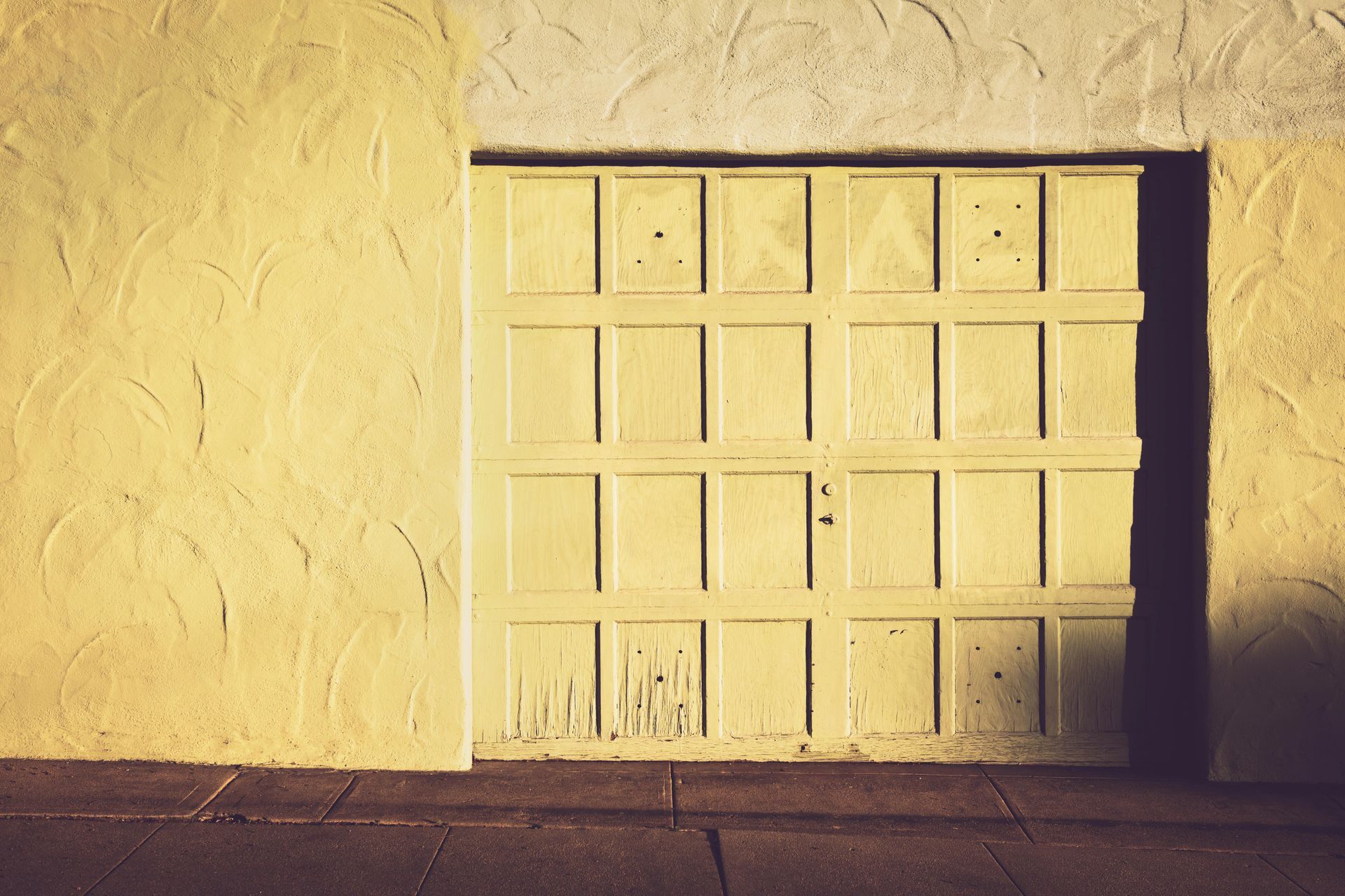 A yellow wall with a window and a shadow on it.