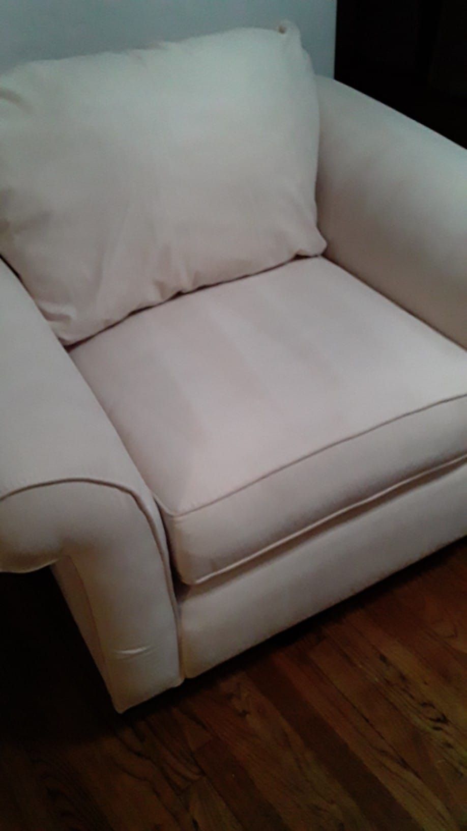 a white chair is sitting on a wooden floor