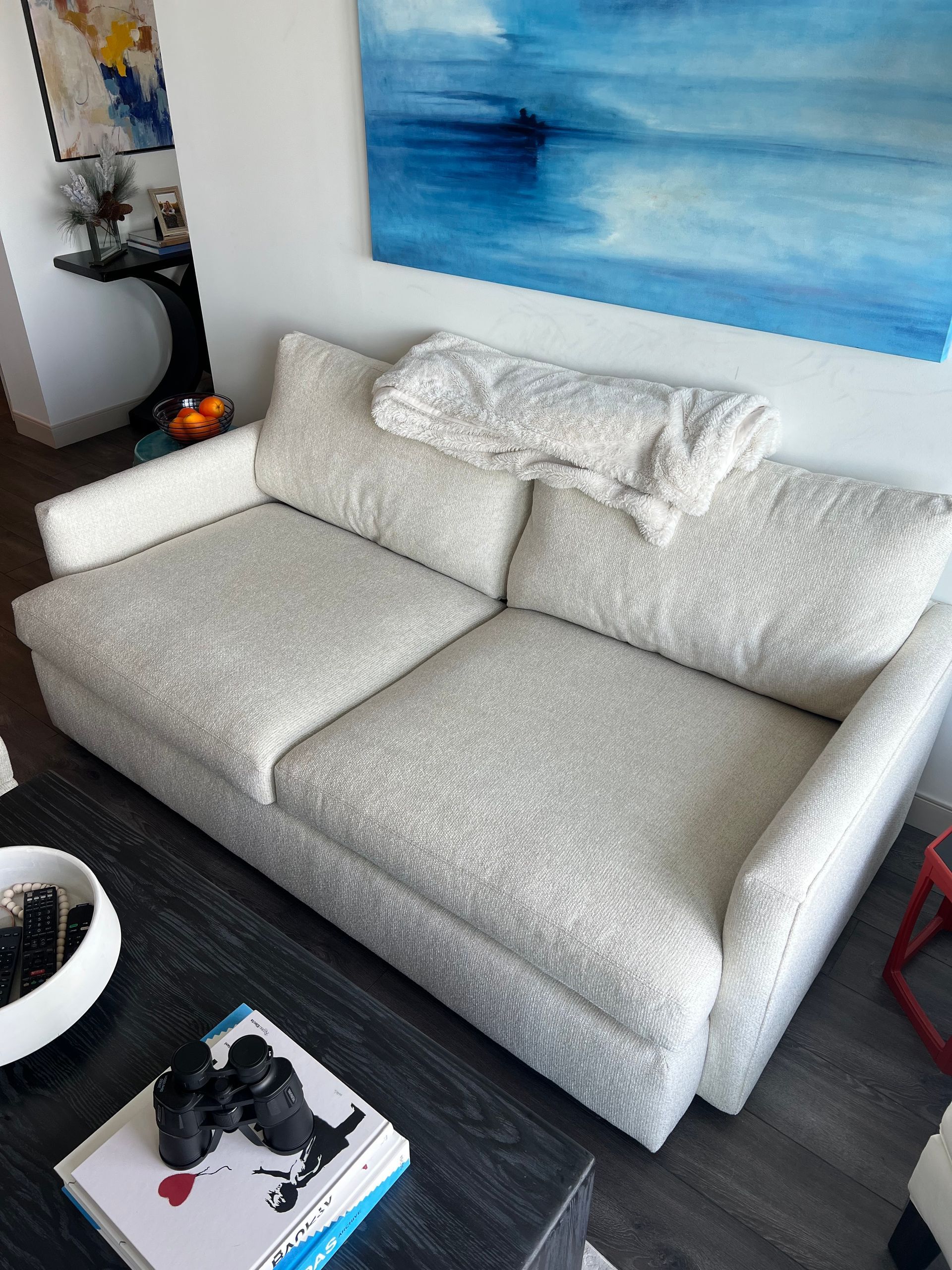 a white couch with a blanket on top of it