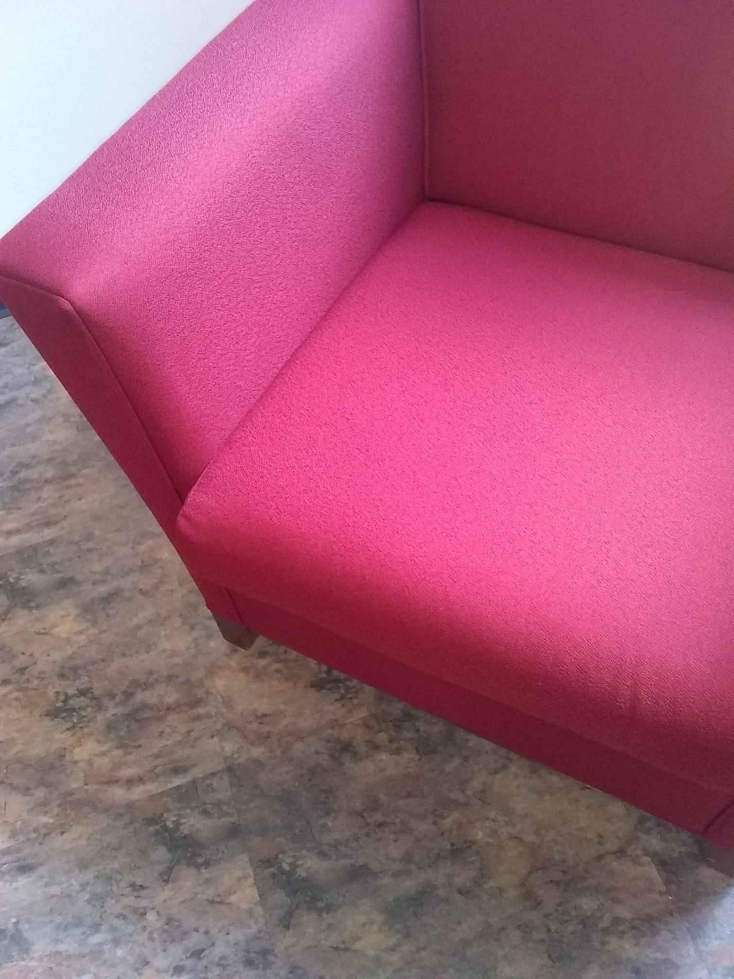 a red couch is sitting on a tiled floor