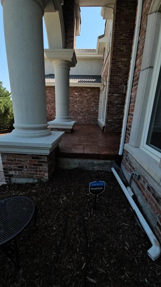 Exterior of a house with brick and columns. 