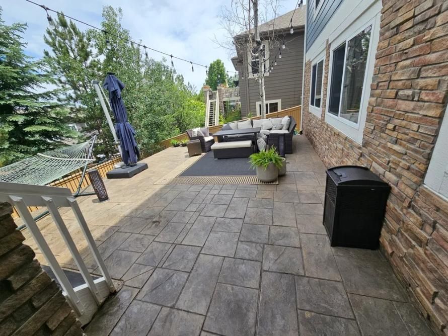Patio with stone pavers, outdoor furniture, and a hammock. 