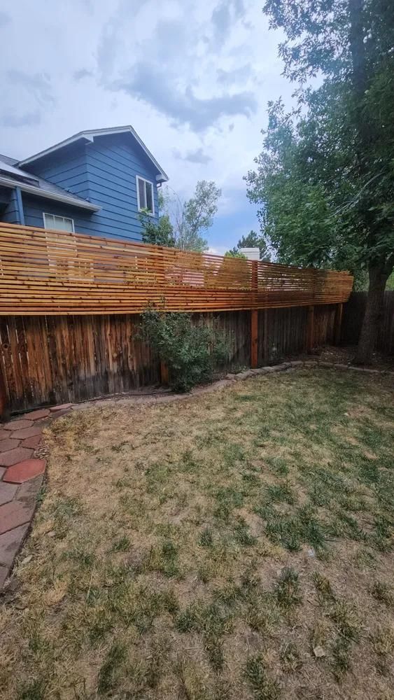 Backyard with brown fence and wooden accent.