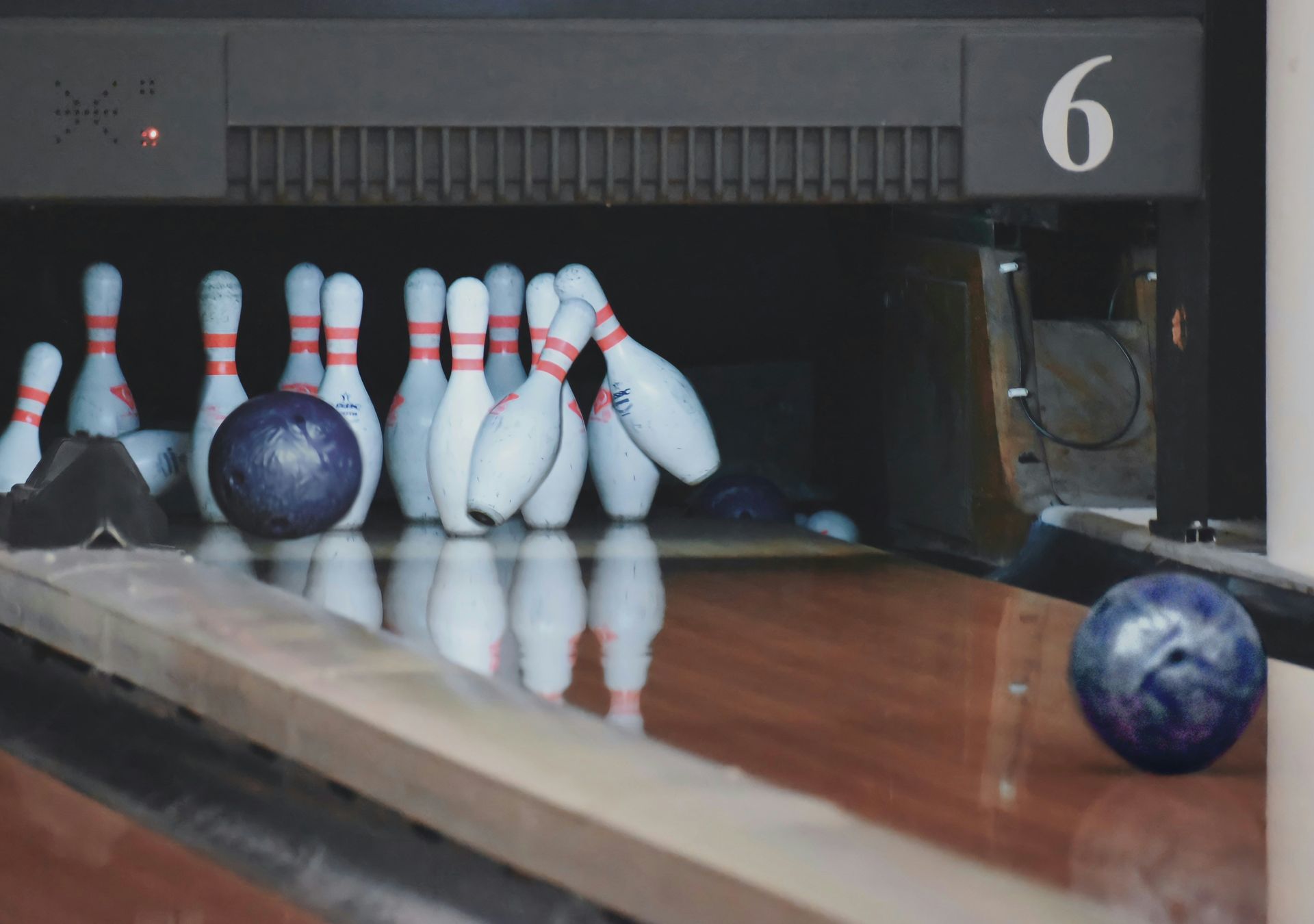 Bowling ball strikes pins; pins scatter across the lane. Number 6 is visible.