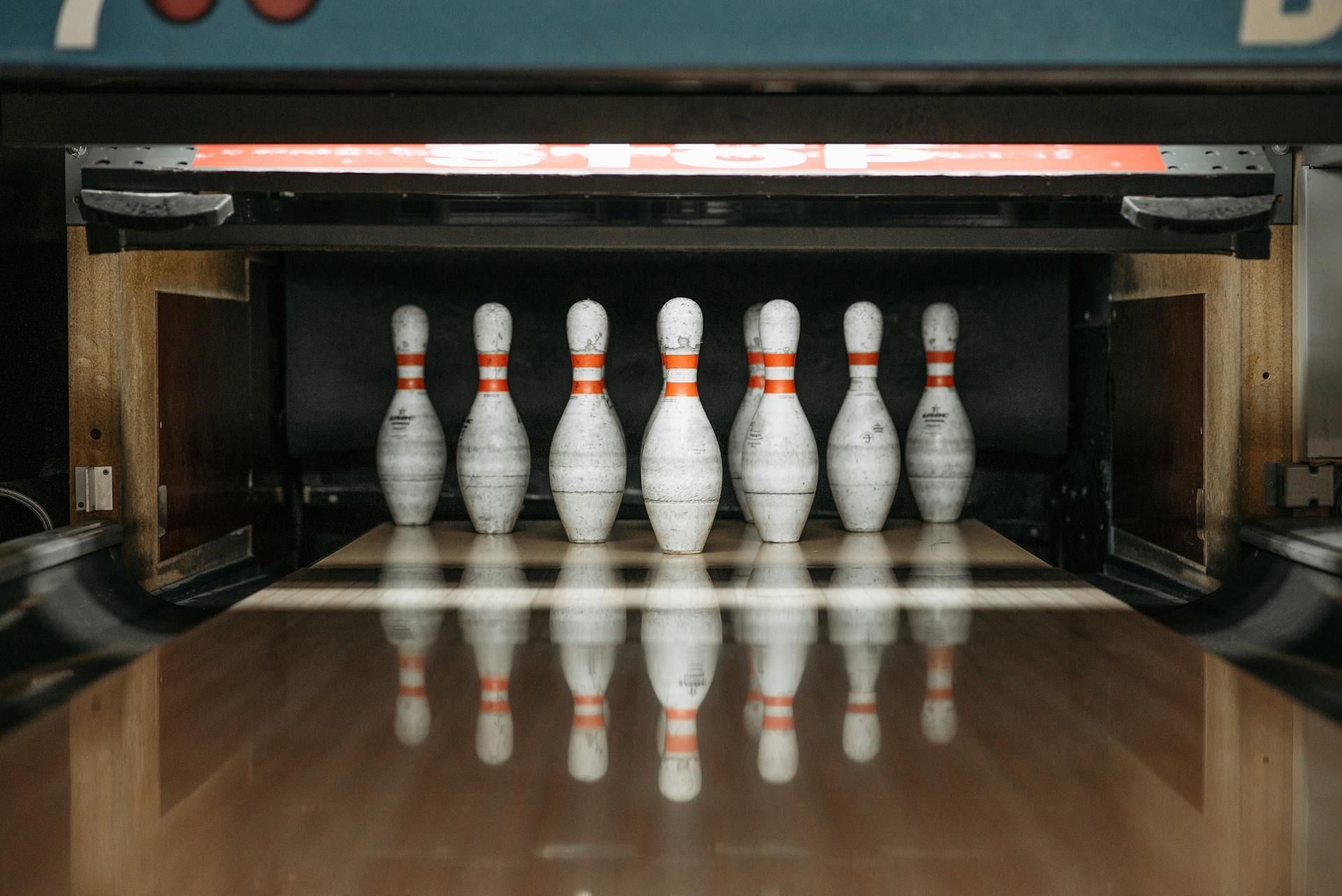 A row of bowling pins are lined up on a bowling alley.