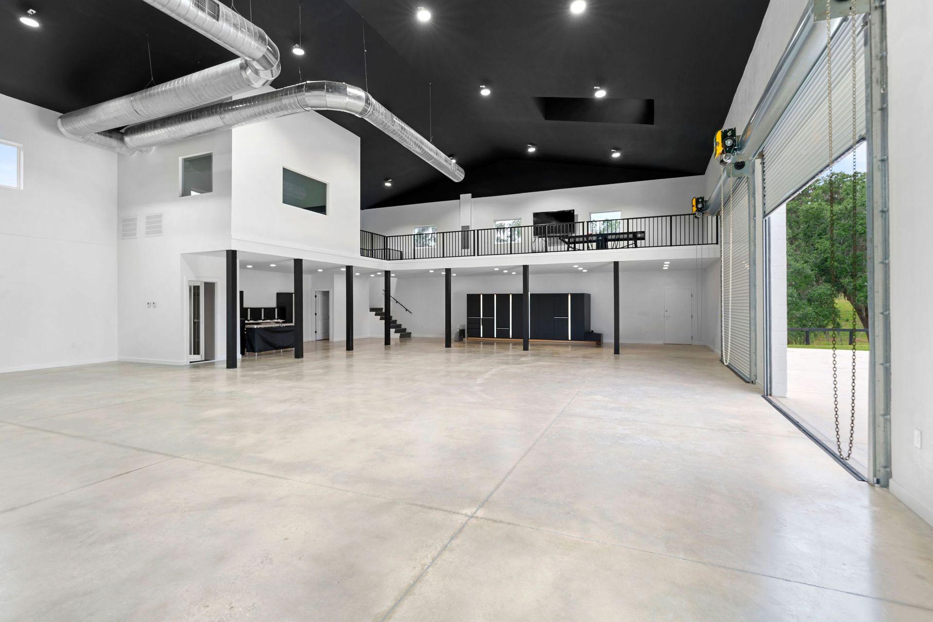 A large empty room with a black ceiling and white walls.