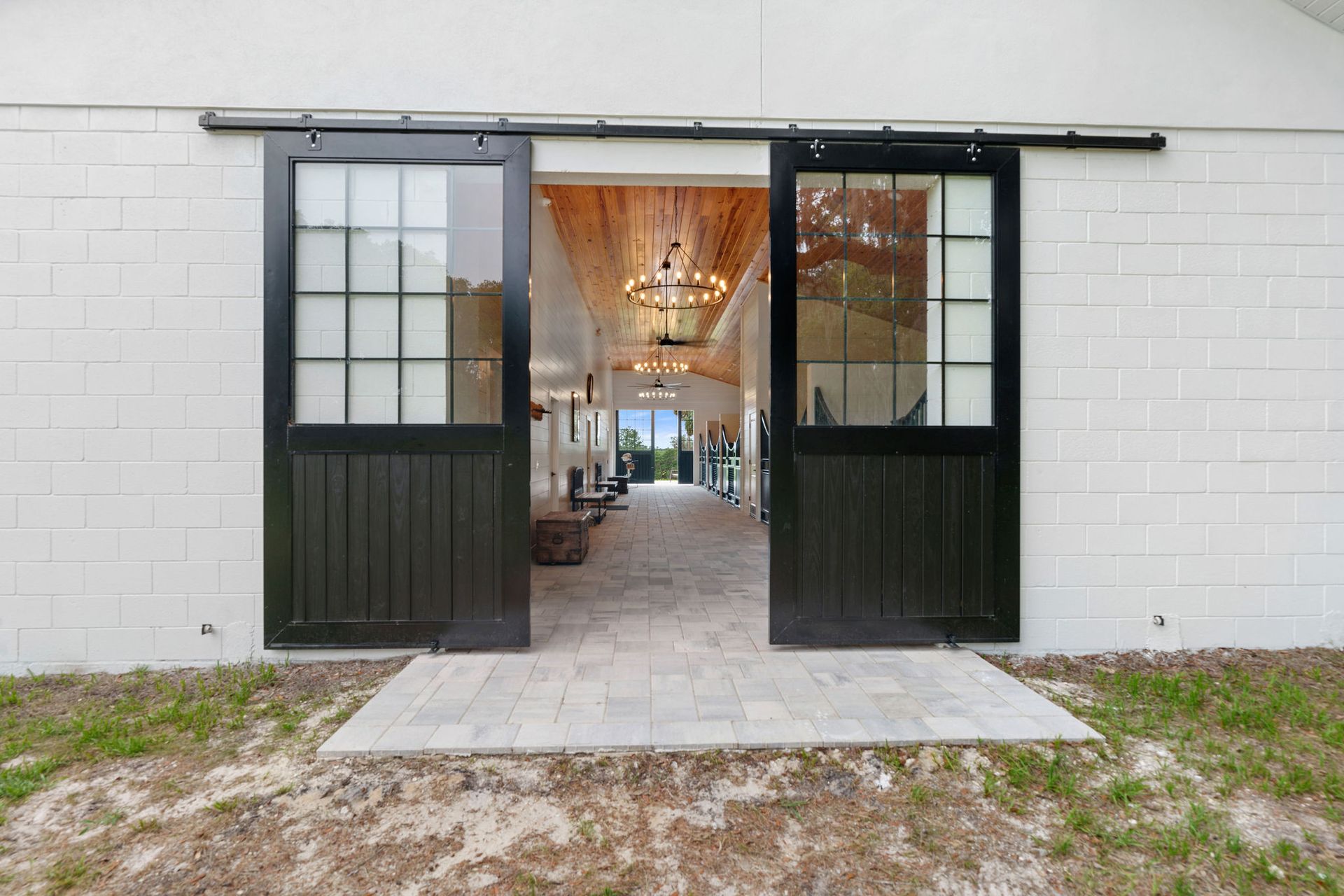 A white brick building with black sliding barn doors.