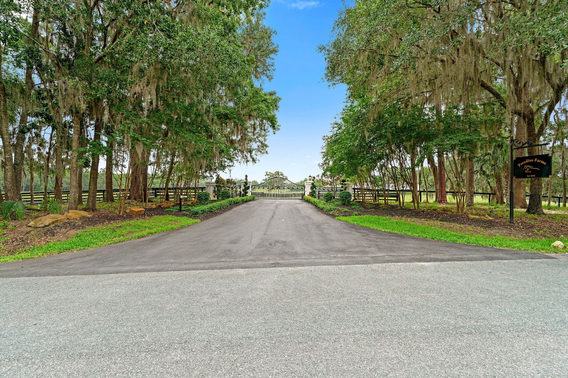 A road with trees on both sides of it and a sign on the side of it.