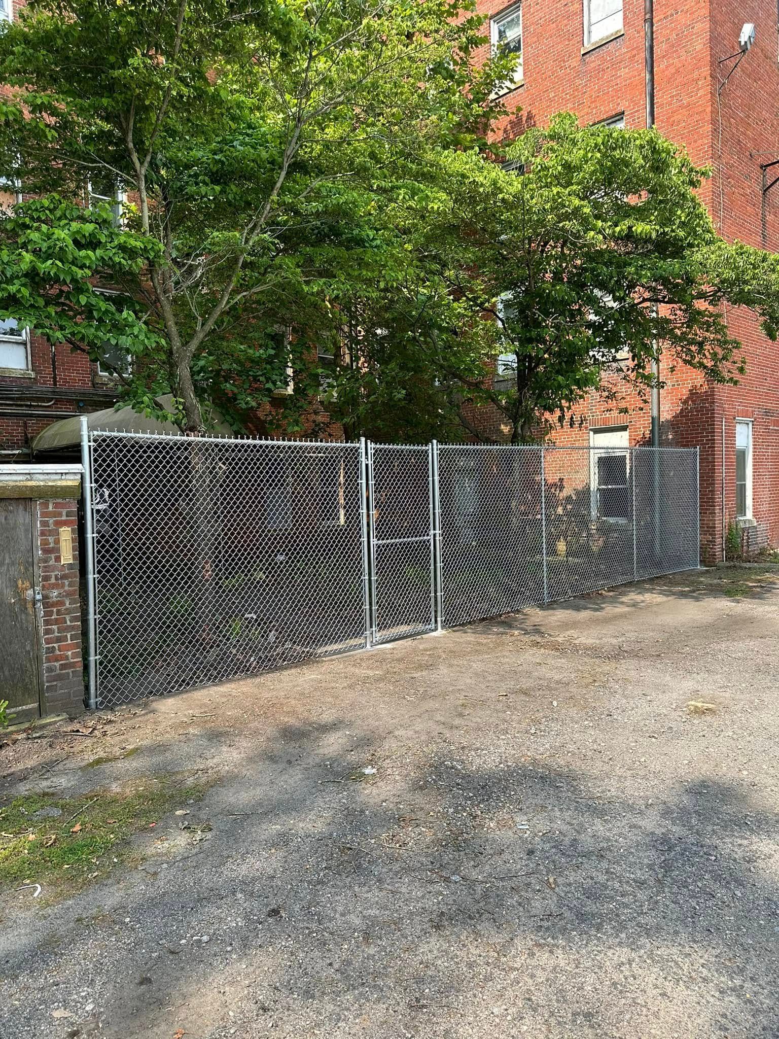Cloudy waterfront view through a black fence, with grassy yard and apartment buildings on both sides. Cloudy waterfront view through a black fence, with grassy yard and apartment buildings on both sides.