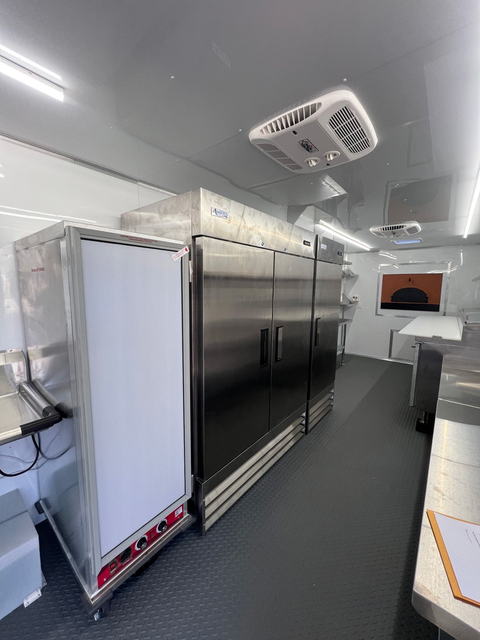 Industrial walk-in cooler with stainless steel double doors and white ceiling-mounted refrigeration units