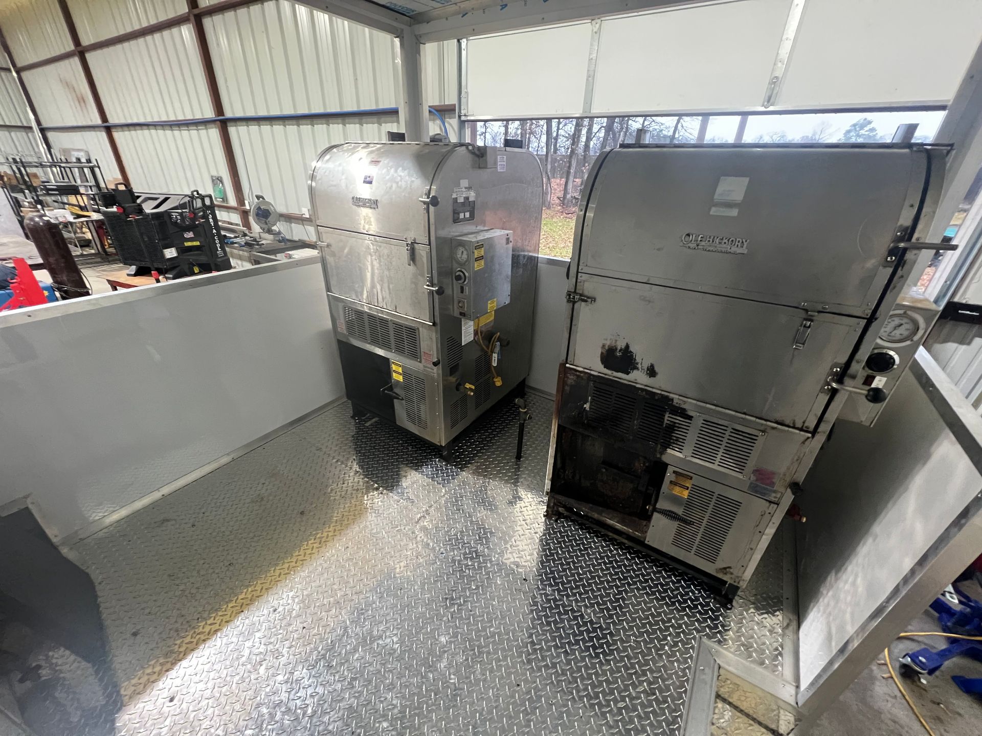 Industrial machinery in a Trailer Repair workshop, with two large gray machines and metal shavings on the floor.