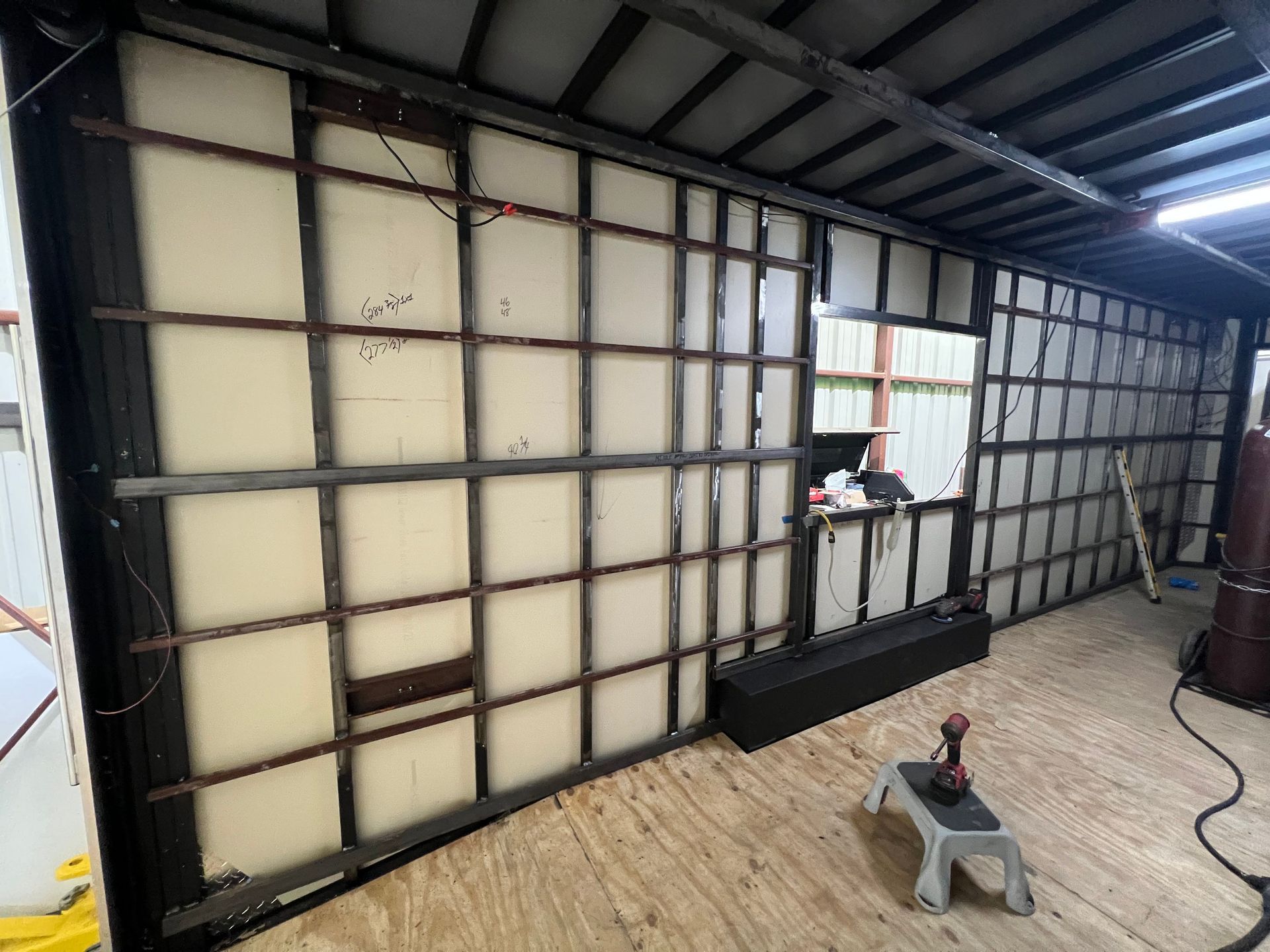 Interior of a long cargo truck trailer with exposed wall framing, insulation panels.