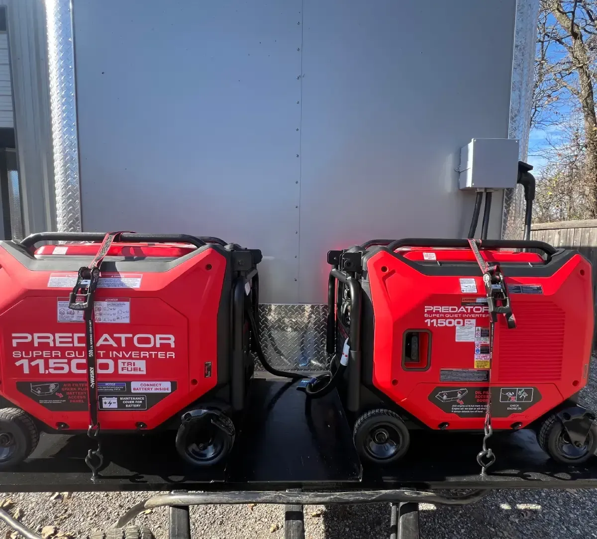Two red Predator 1700 generators strapped side by side on a trailer outdoors