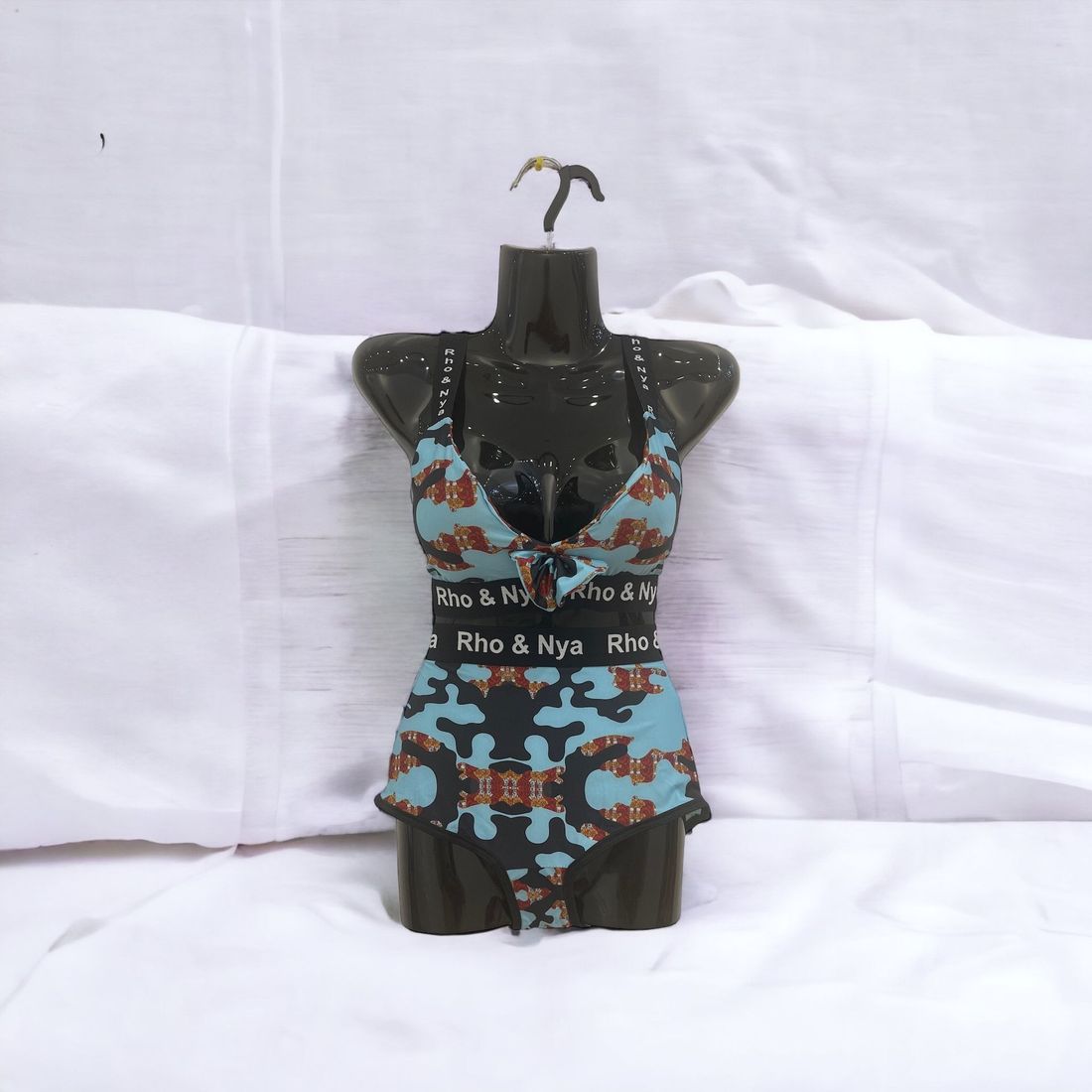 A mannequin is wearing a swimsuit that says rho & nya