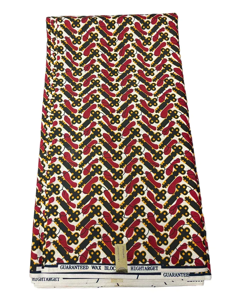 Folded patterned fabric with red, gold, and black floral and geometric design
