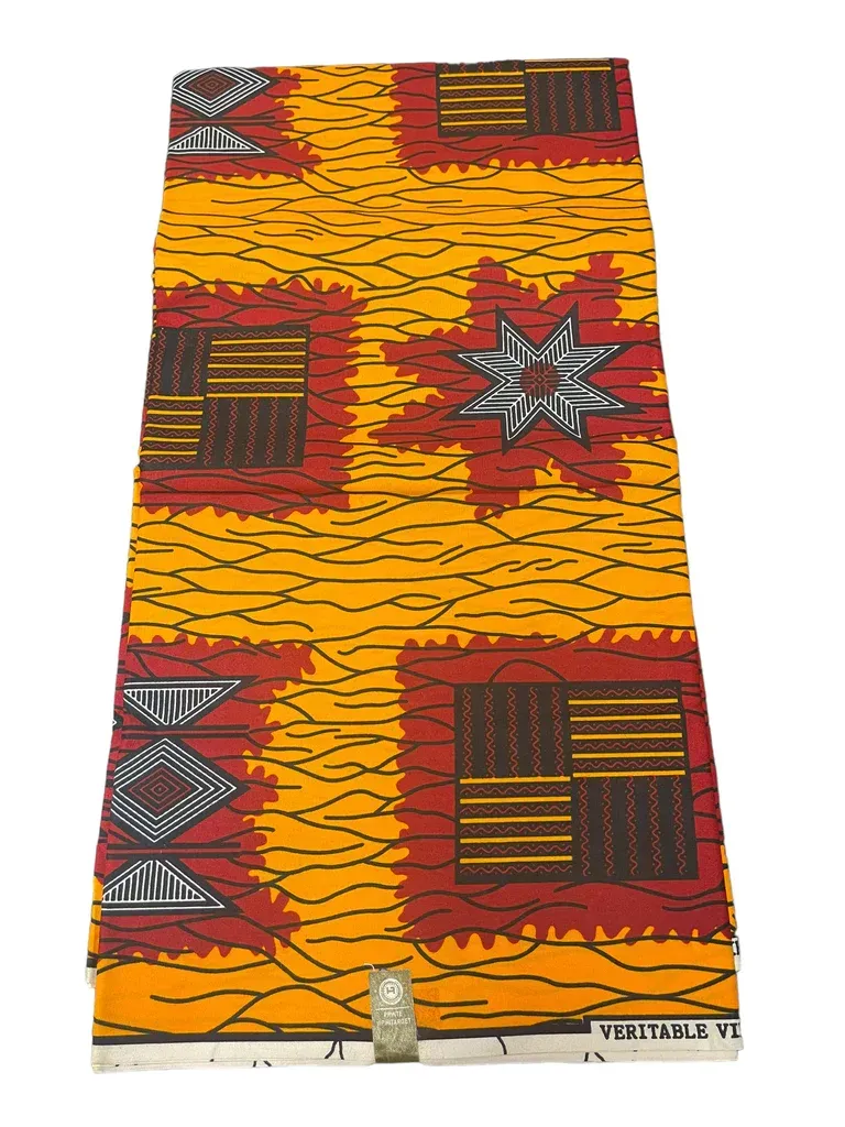 Orange patterned fabric with red and brown geometric shapes and star motifs