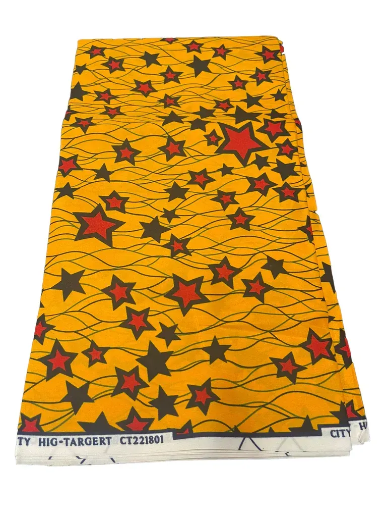 Yellow patterned fabric with red and black stars on a white backing