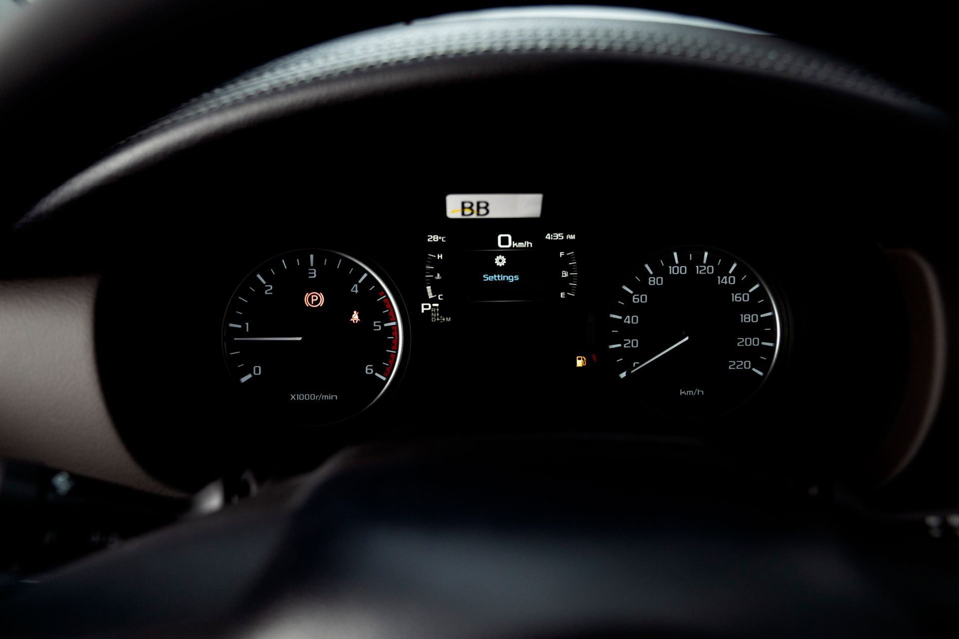 Car dashboard illuminated, showing speedometer, gauges, and digital display.