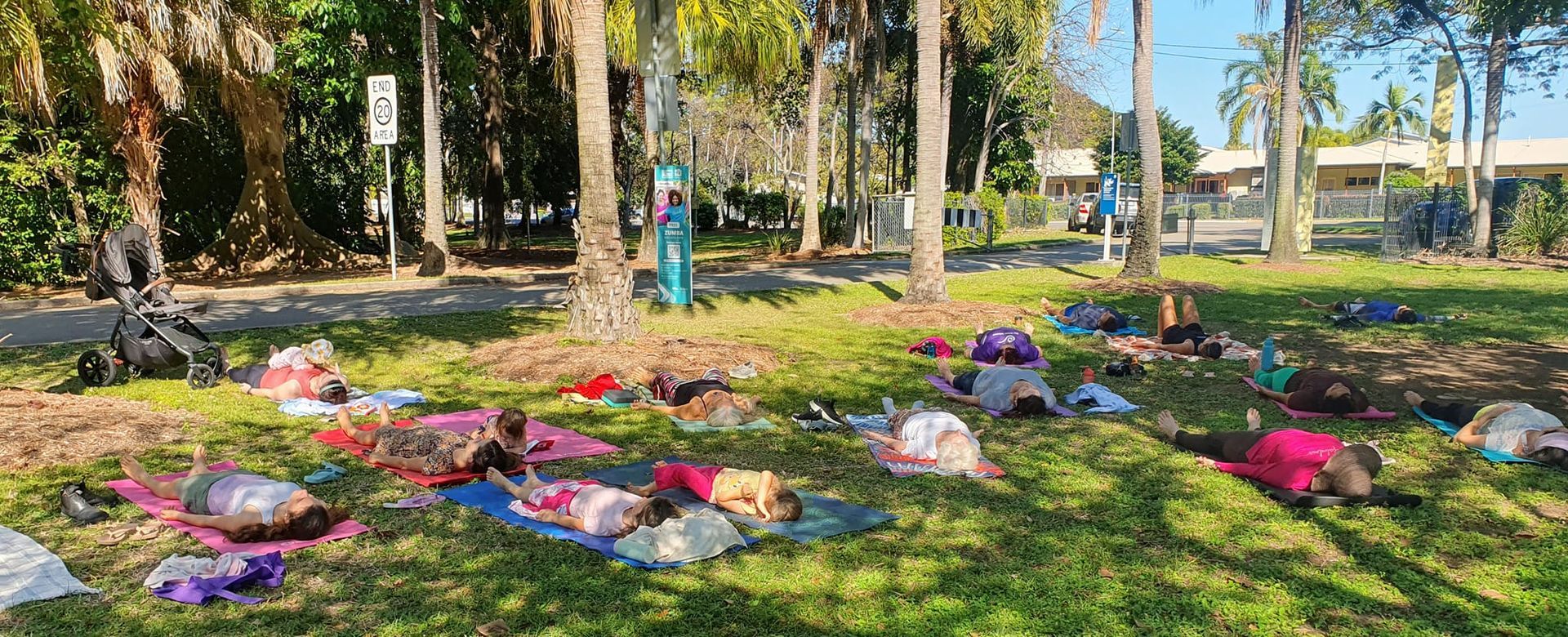 People Doing Yoga on Mats in a Grassy Park, Trees in the Background — Skilful Living in North Ward, QLD
