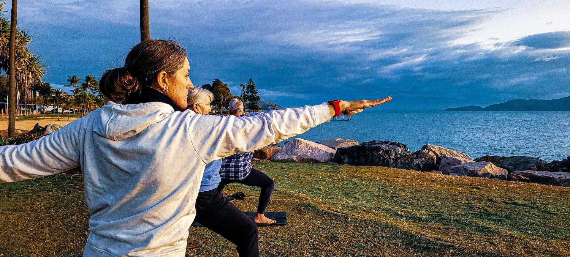 Two People Doing Yoga by the Ocean at Sunset — Skilful Living in North Ward, QLD