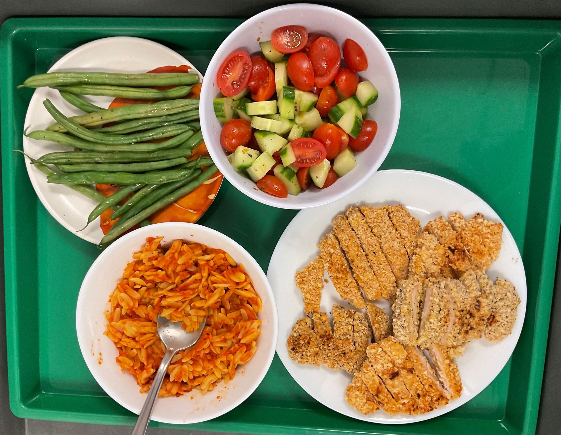 A green tray filled with different types of food
