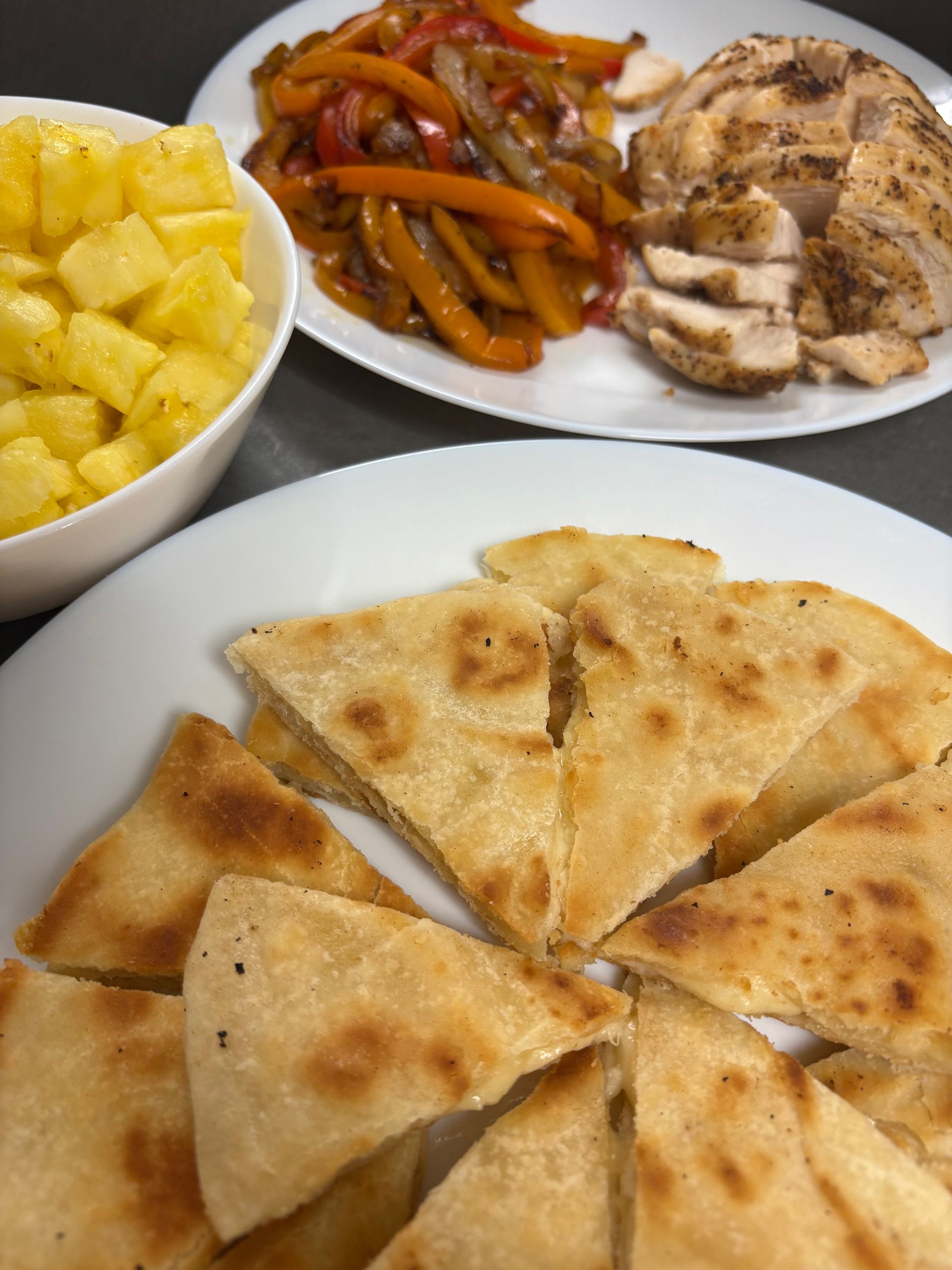A plate of pita bread next to a bowl of pineapple