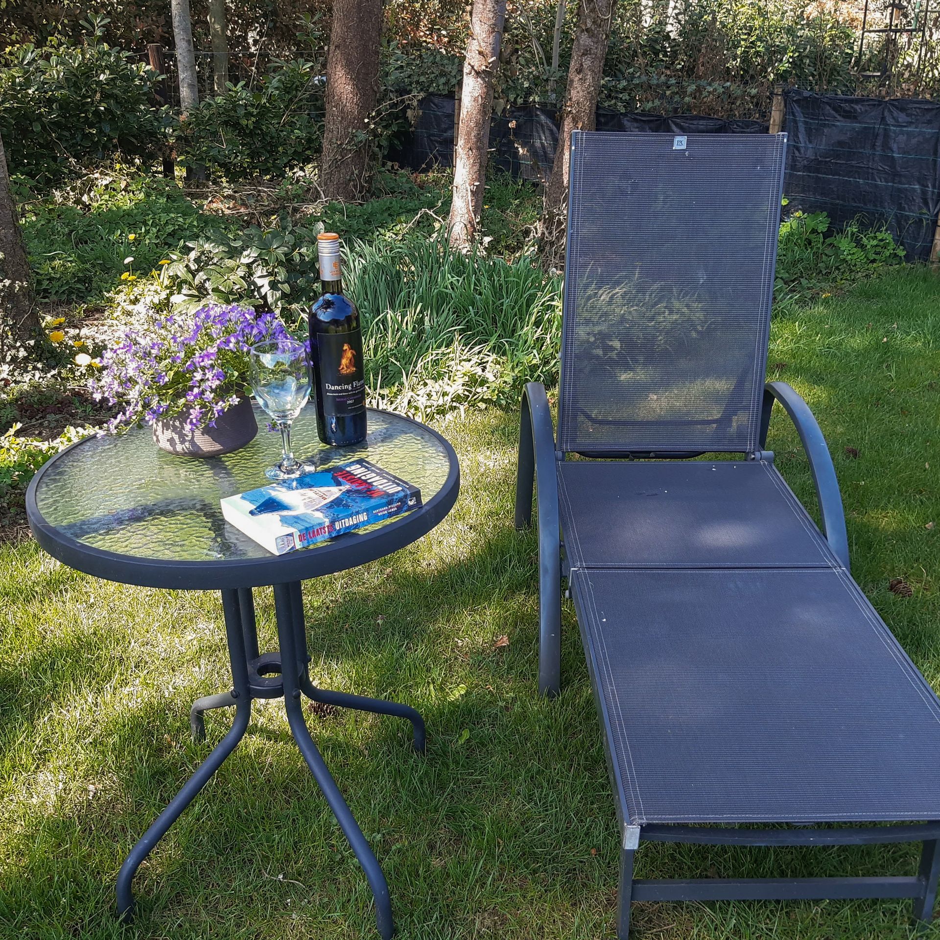 Een fles wijn staat op een tafel naast een stoel