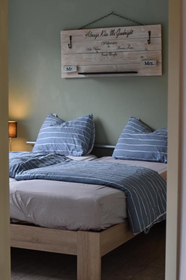 Een slaapkamer met een bed en een bordje aan de muur erboven.