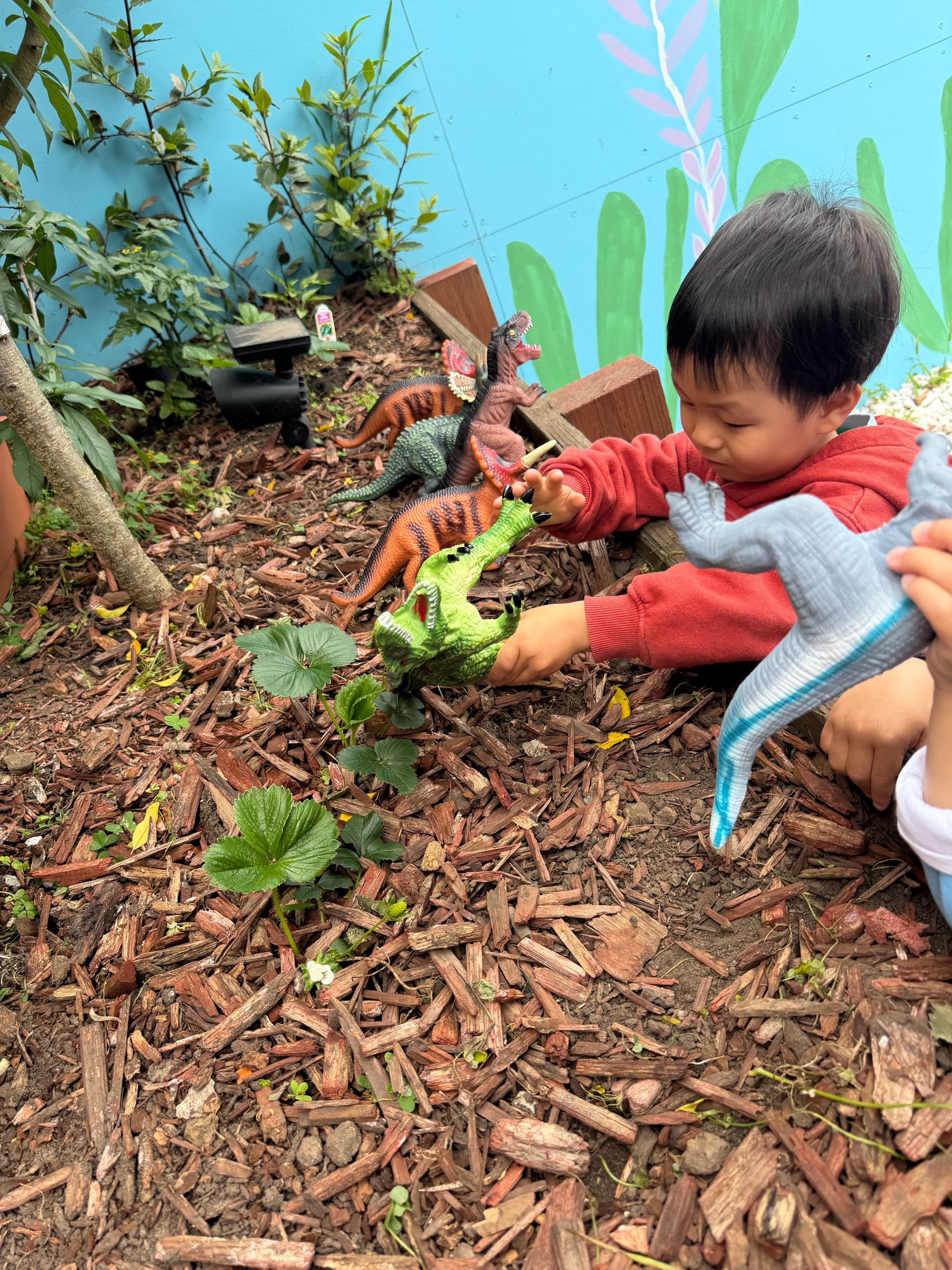 A baby wearing a raccoon costume is playing with toys