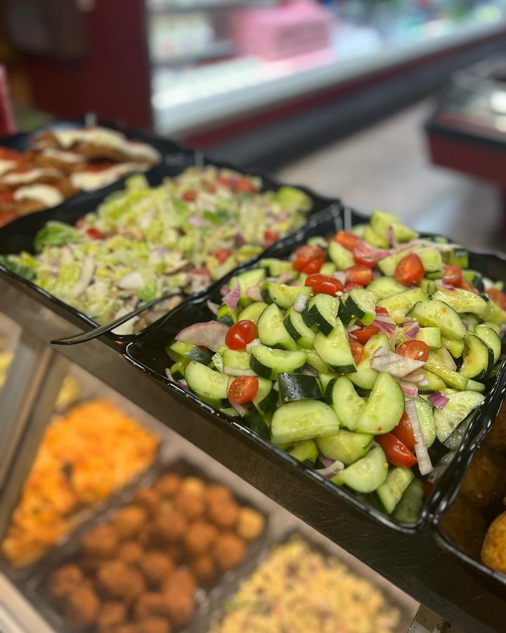 A variety of salads are displayed on a shelf.