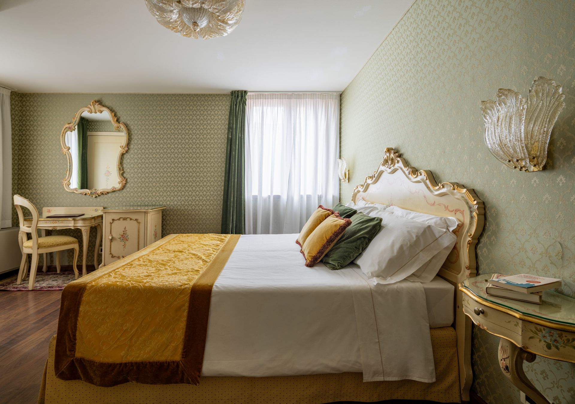 Elegante camera da letto dai toni pastello con mobili dorati decorati, pareti verdi decorate