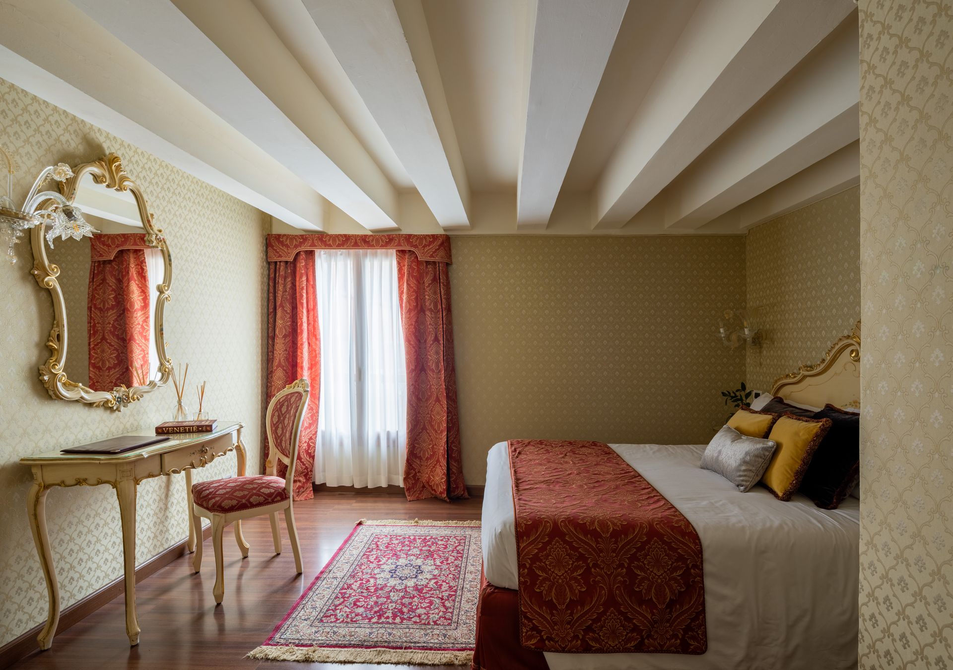 Elegante camera da letto con dettagli rossi, toeletta decorata e tappeto a motivi geometrici