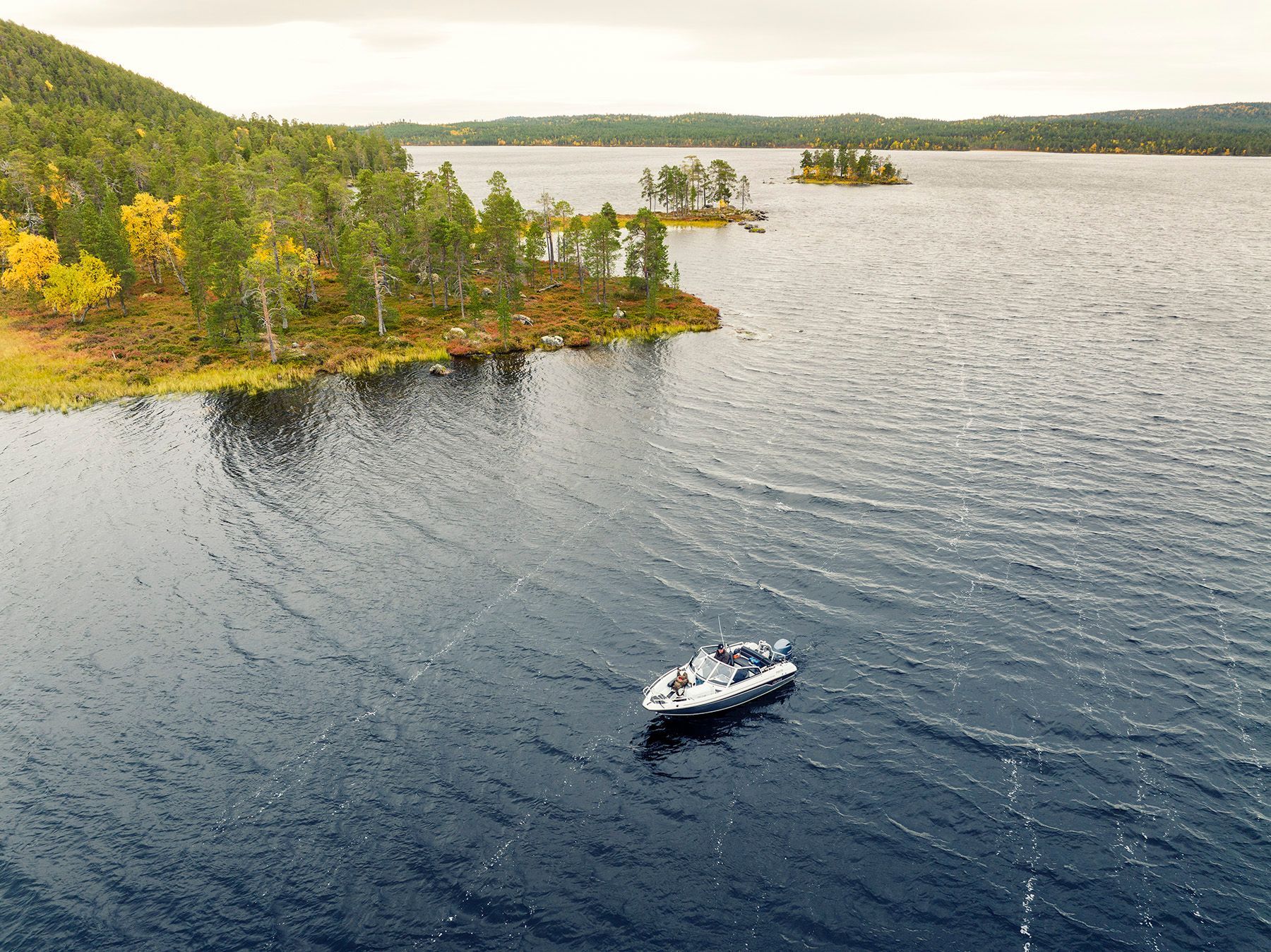 An aerial view of a boat floating on top of a lake.